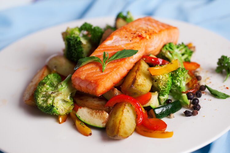 salmon fillet with vegetables and basil on a plate